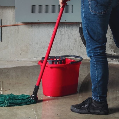 Unidentifiable person mopping up after a flood. Florida water damage and restoration.